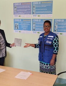 Dr. Karen Lewis-Bell hands over the COVID-19 diagnostic test kits to Dr. Cleopatra Jessurun  Director of the ministry of Public Health.