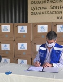 Representante de OPS y autoridad local durante entrega de las mascarillas