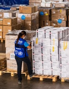 woman checks boxes in a warehouse