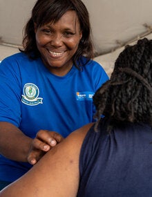 A nurse prepares to vaccinate an adult