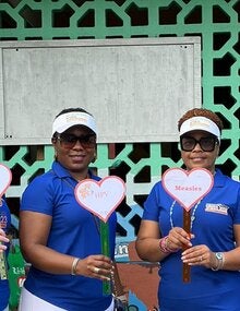 Group standing with vaccination placards