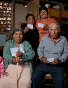 family holding up their vaccination cards at home