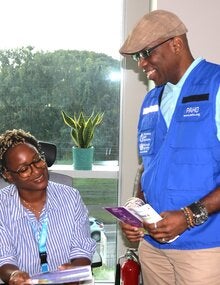 L-R (seated) Dr Ayanna Alexander , Technical Officer - Health Promotion, Life Course, and Determinants and (standing) Dr Stephen Nurse-Findlay, Advisor, Communicable Disease Control and Elimination review the printed Hansen’s disease communication materials.