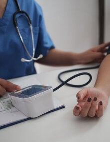 Enfermera midiendo la presión arterial de la paciente