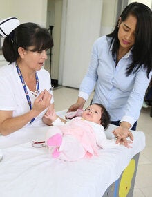 Enfermera vacuna a bebé