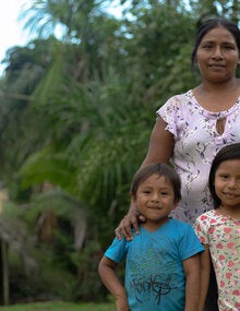 A mother in the Amazon with her smiling daughter and son