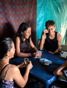 Una familia juega cartas: padres e hijos.