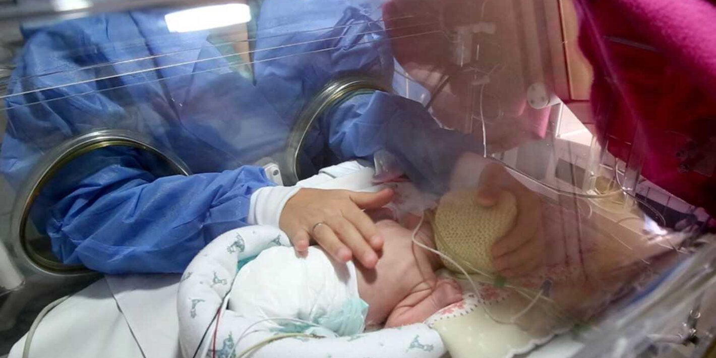 Madre mira a su hija en la incubadora