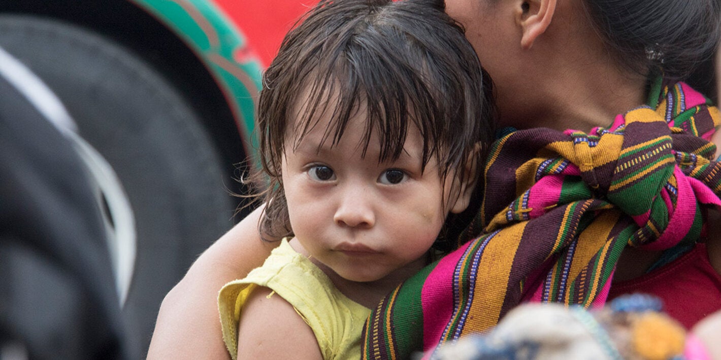 indigenous woman carrying a child