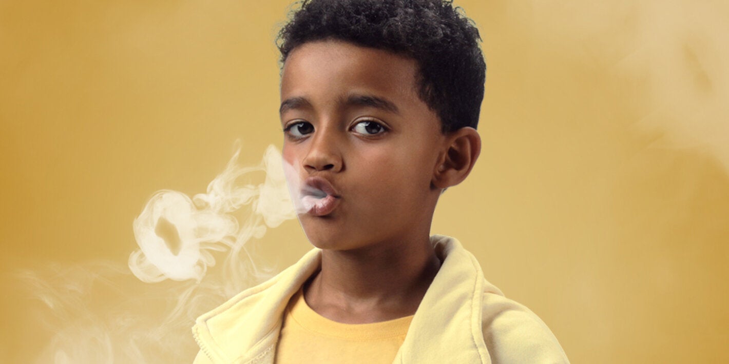 Niño simulando fumar 