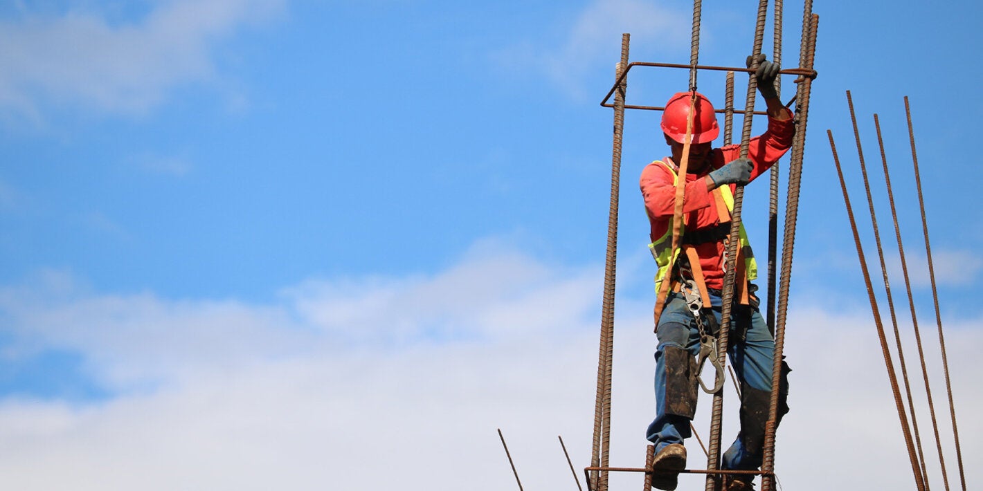Un trabajador de la construcción se encuentra en una barra de metal.
