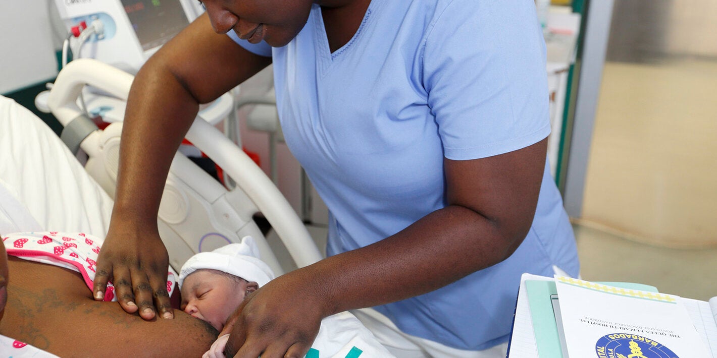 Nurse aids new mom with breastfeeding