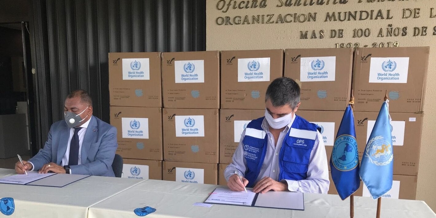 Representante de OPS y autoridad local durante entrega de las mascarillas