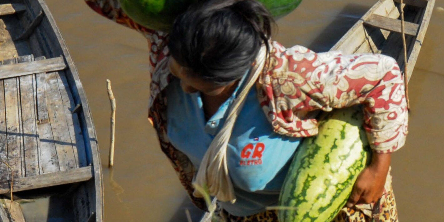 Woman with watermelons and fish in hand