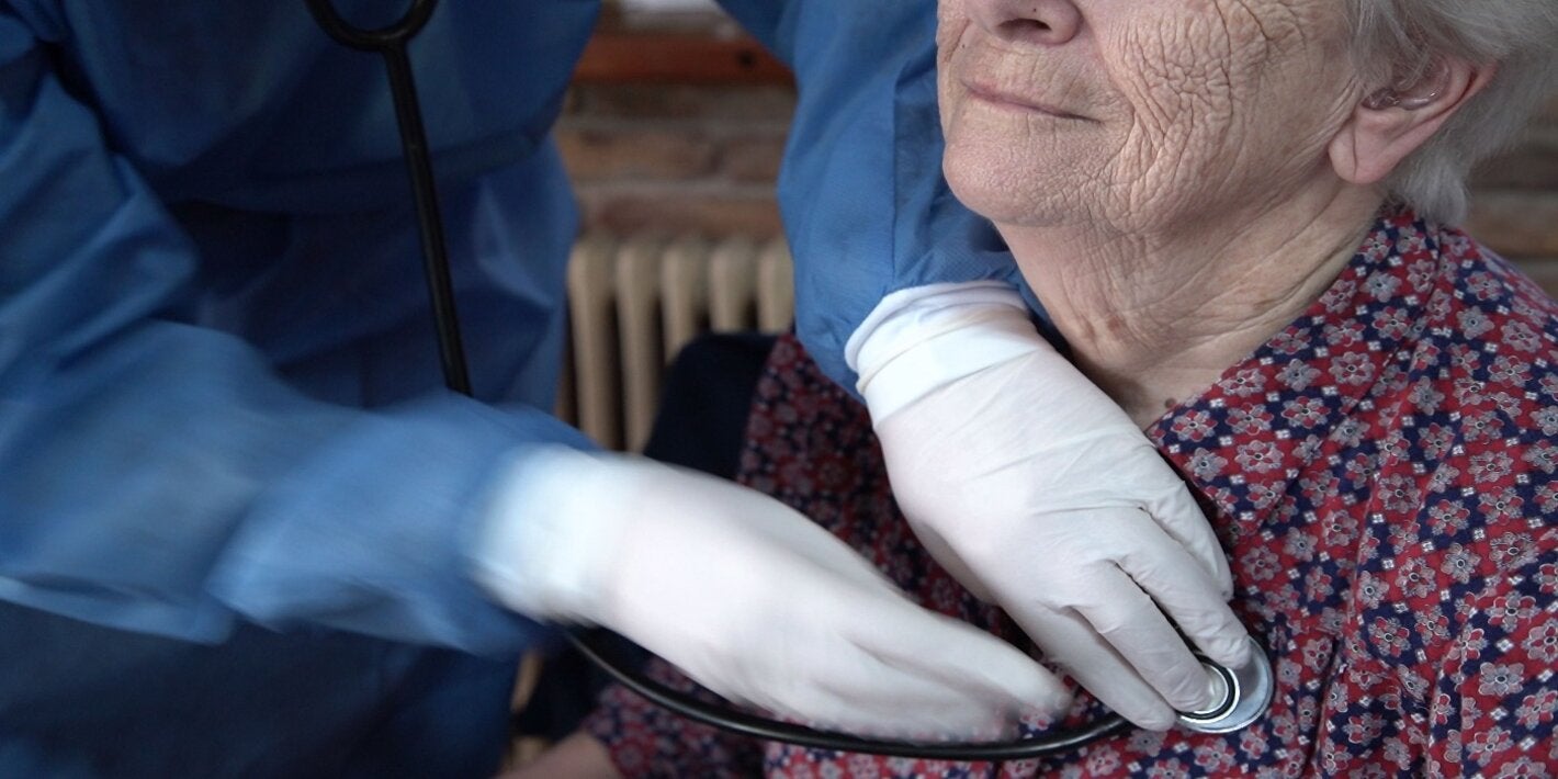  Un miembro del personal de la clínica ayuda a una mujer mayor.