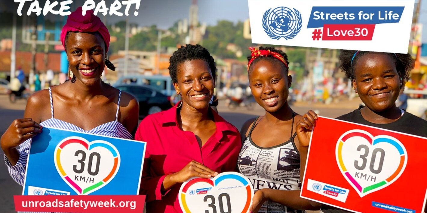 Imagen de cuatro mujeres afrodescendientes sonriendo y mostrando carteles con un corazón con el número 30 en medio.  
