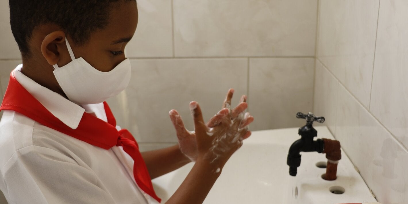 Niño se lava las manos en escuela cubana