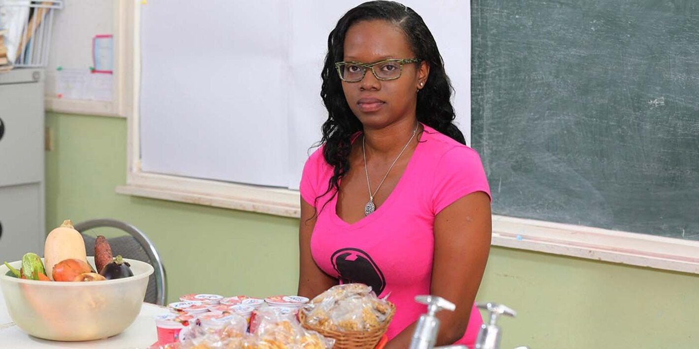 Nicole Griffith sitting before a table covered with various healthy foods