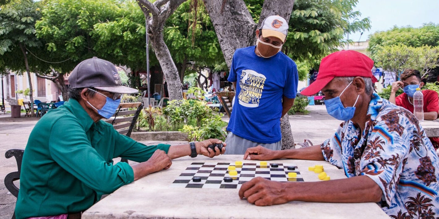 Señores jugando tablero con medidas preventivas