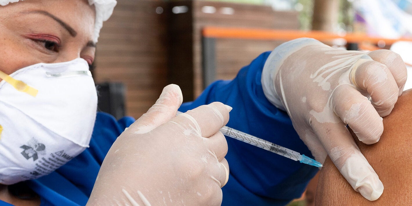 Health worker applies COVID-19 vaccine