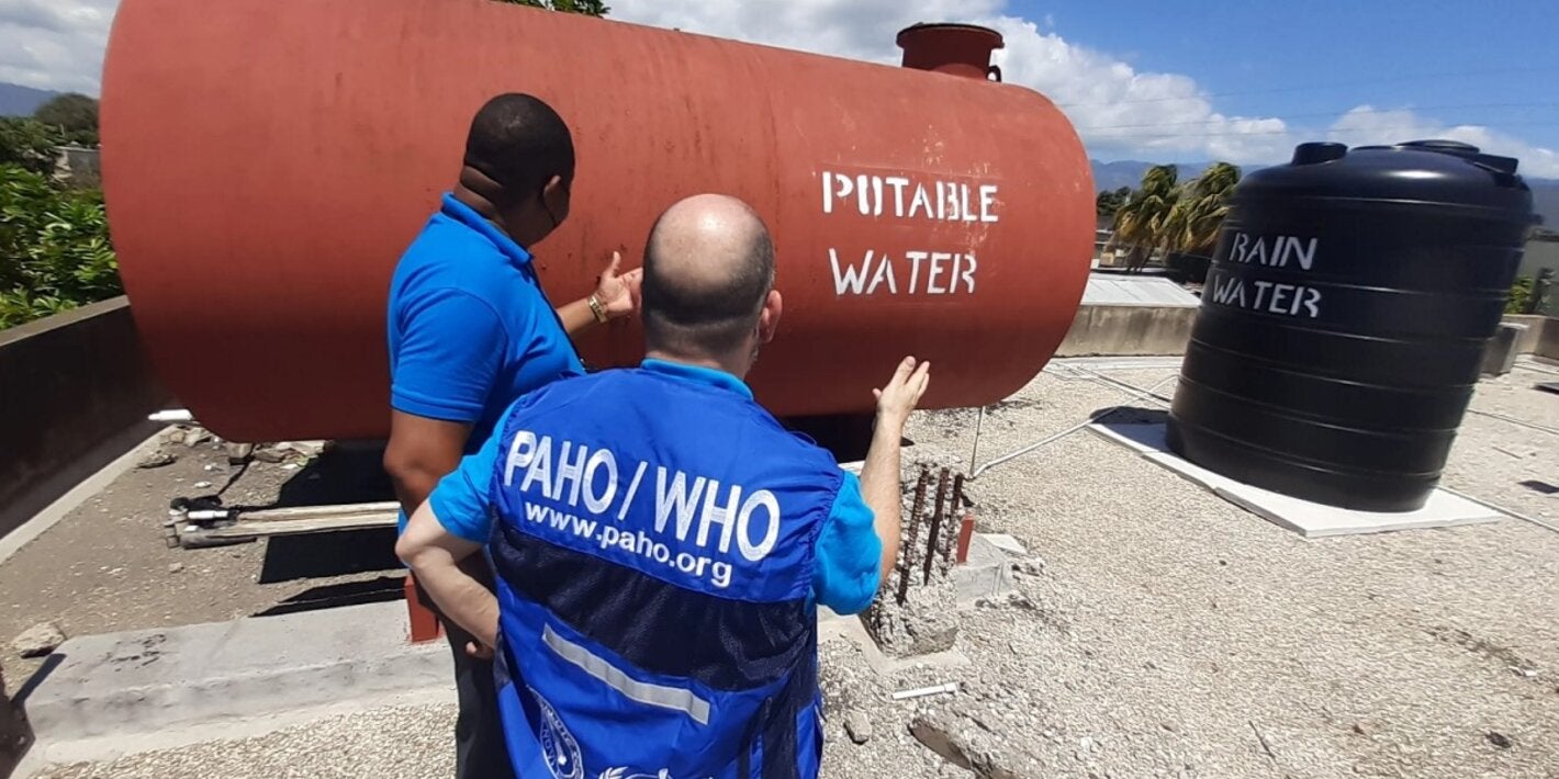 Representatives from the Pan American Health Organization/ World Health Organization Country Office in Jamaica view rainwater and potable water tanks on the roof of the Denham Town Health Centre