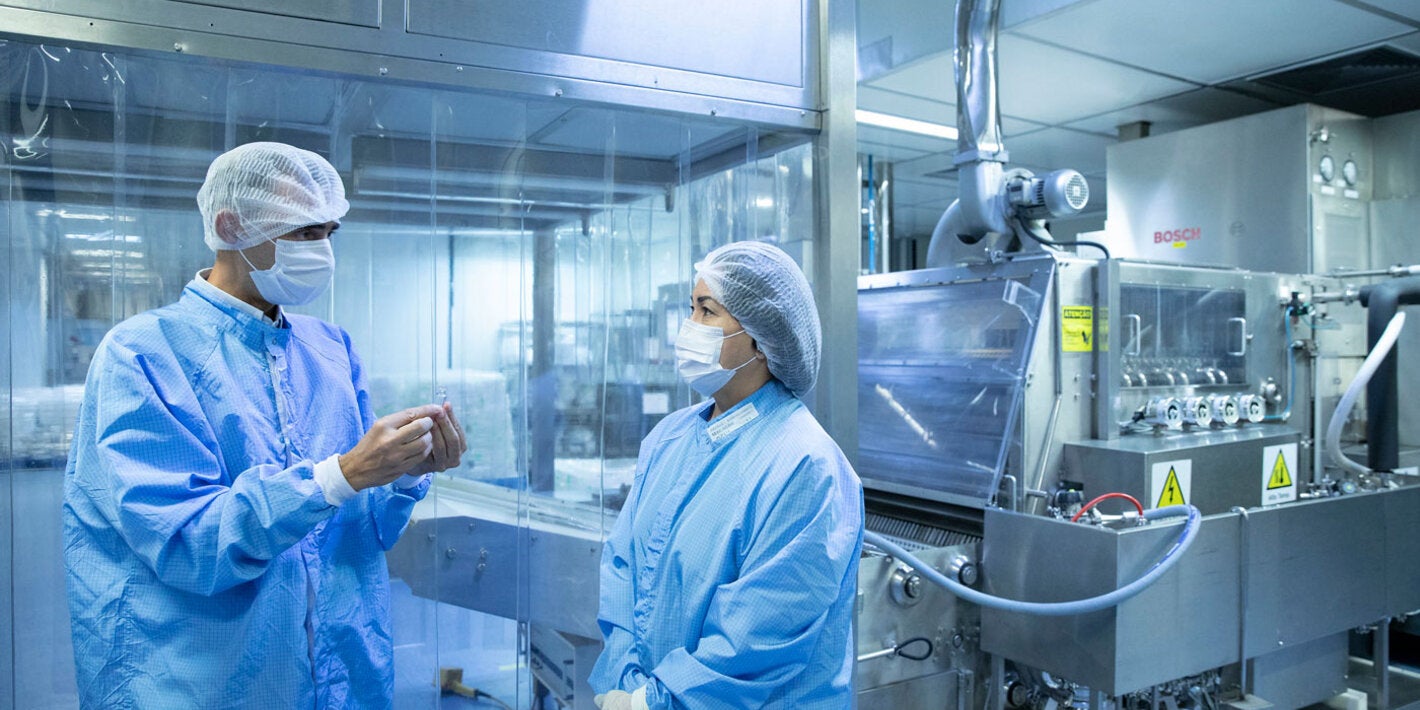 Luiz Lima, Deputy Director of Production at Bio-Manguinhos-Fiocruz, working with a colleague.