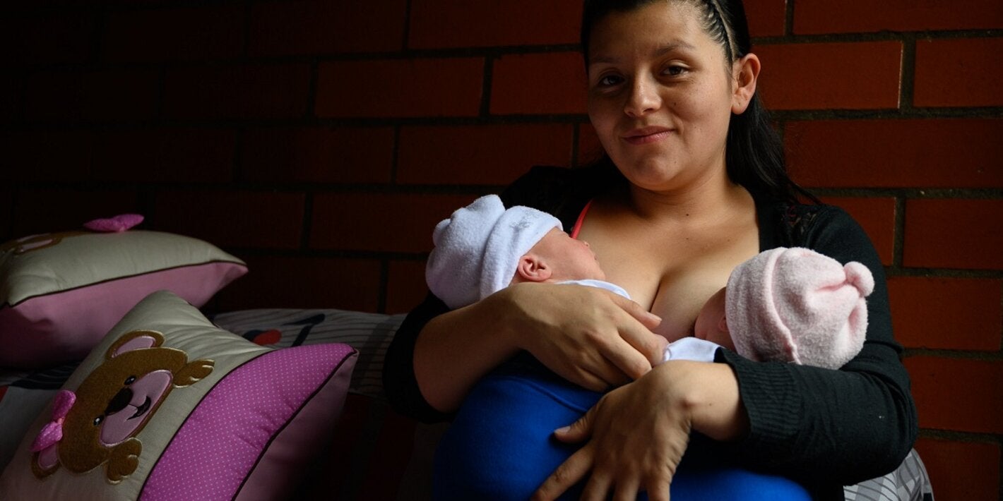 Mulher amamentando dois bebês