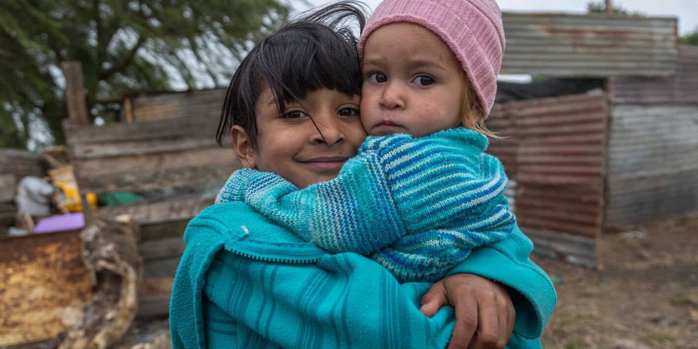 Girls with baby in her hands in impoverished area