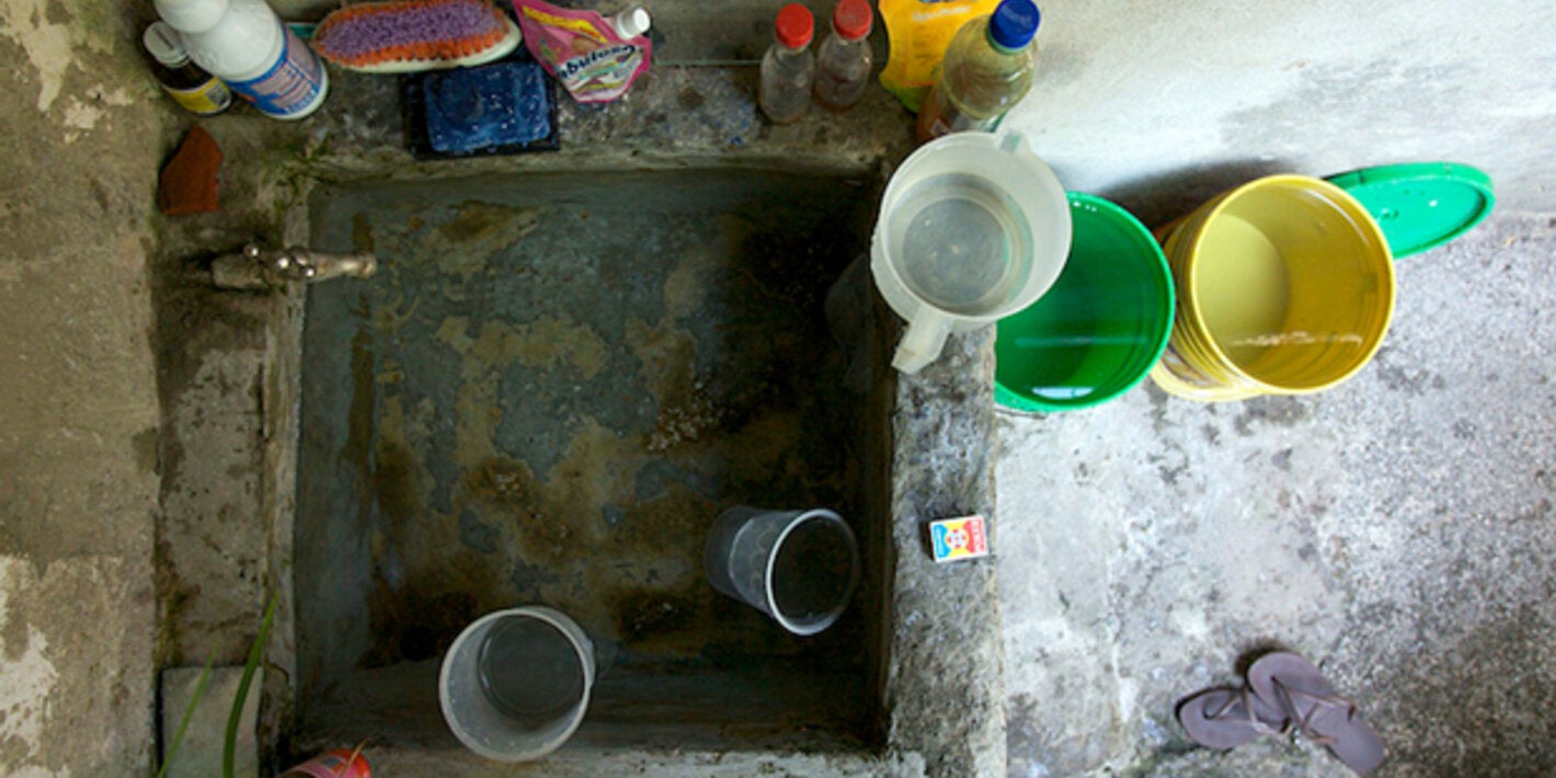 A community health officer visits a house to educate the owner and check water storage to control mosquito breeding sites, Colombia. PAHO/WHO, J Dempster
