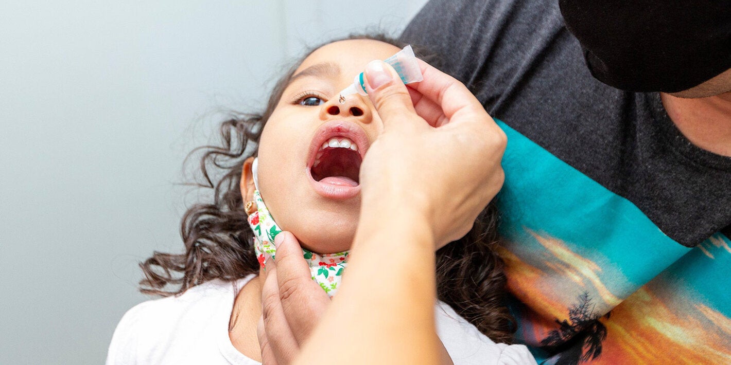 Menina tomando vacina contra pólio