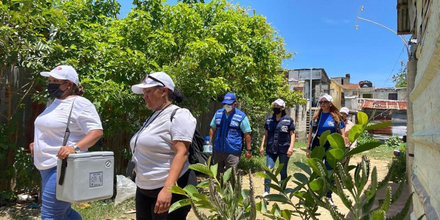 Health workers carrying vaccines in coolers to remote areas