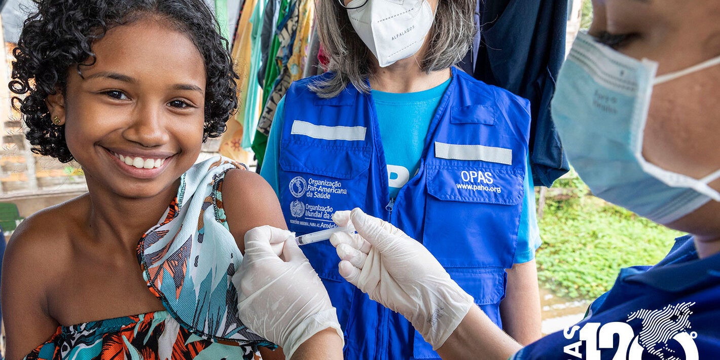 Criança sorrindo recebendo a vacina