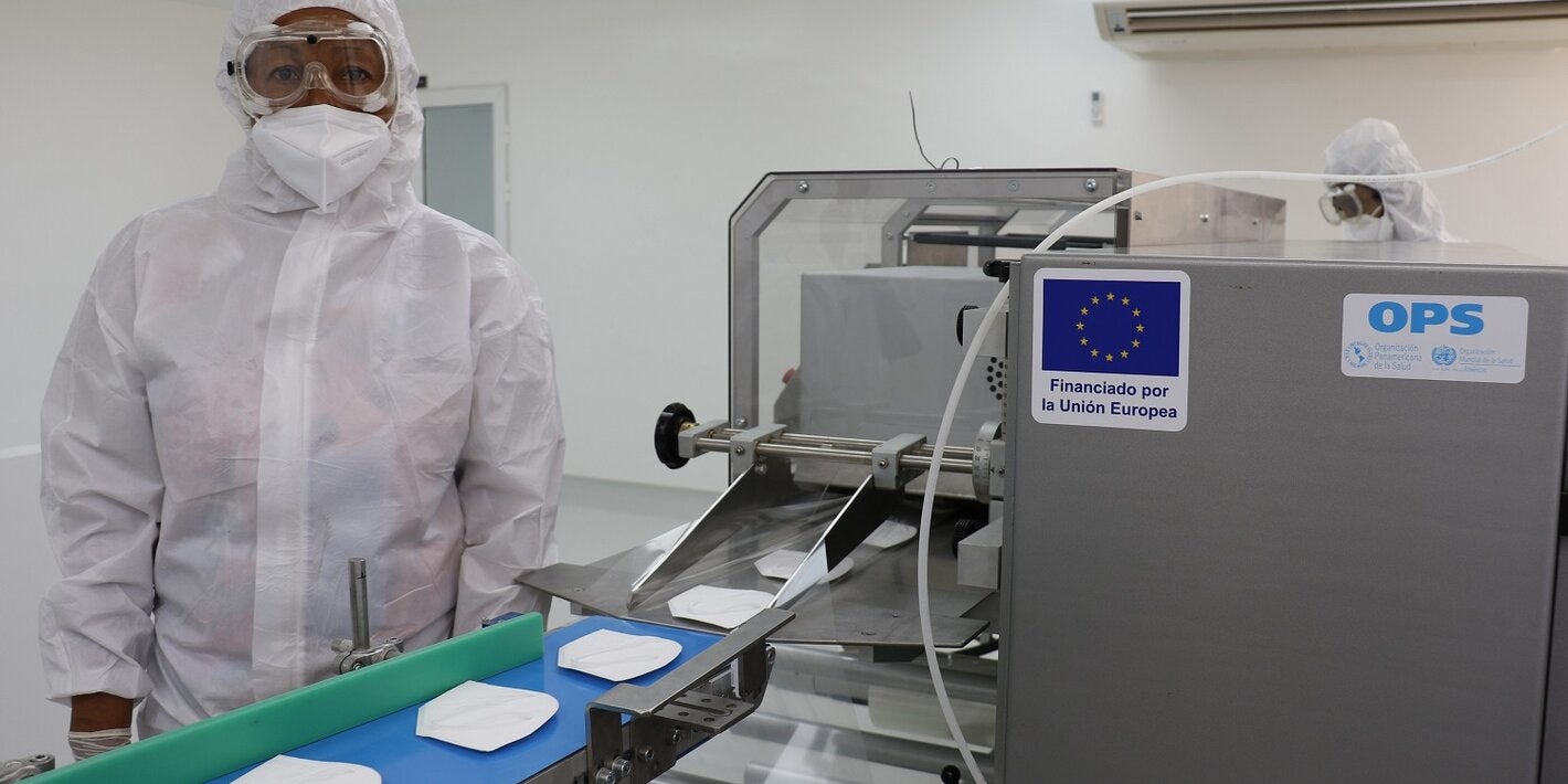 Operaria trabaja en línea de mascarillas