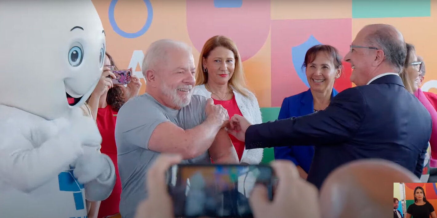 Presidente do Brasil recebe a vacina do vice-presidente, dra. Socorro Gross está entre os dois ao fundo