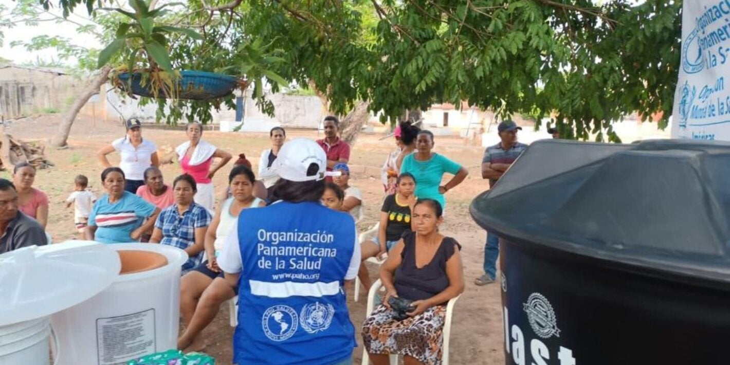 personal de OPS entregando filtros y tanques  de agua a comunidad