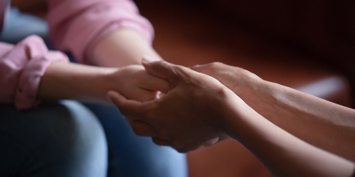 Deux personnes se tiennent la main en signe de soutien.