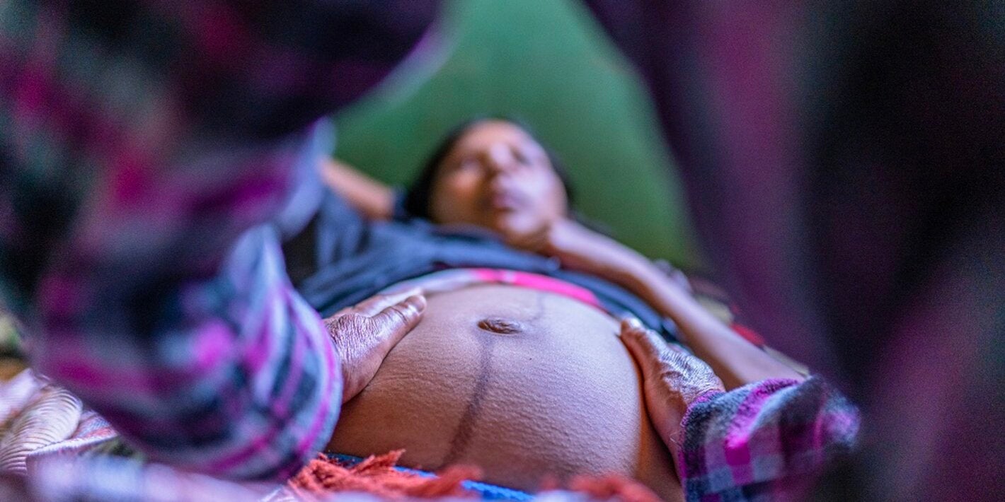 Mujer embarazada y manos sobre su panza