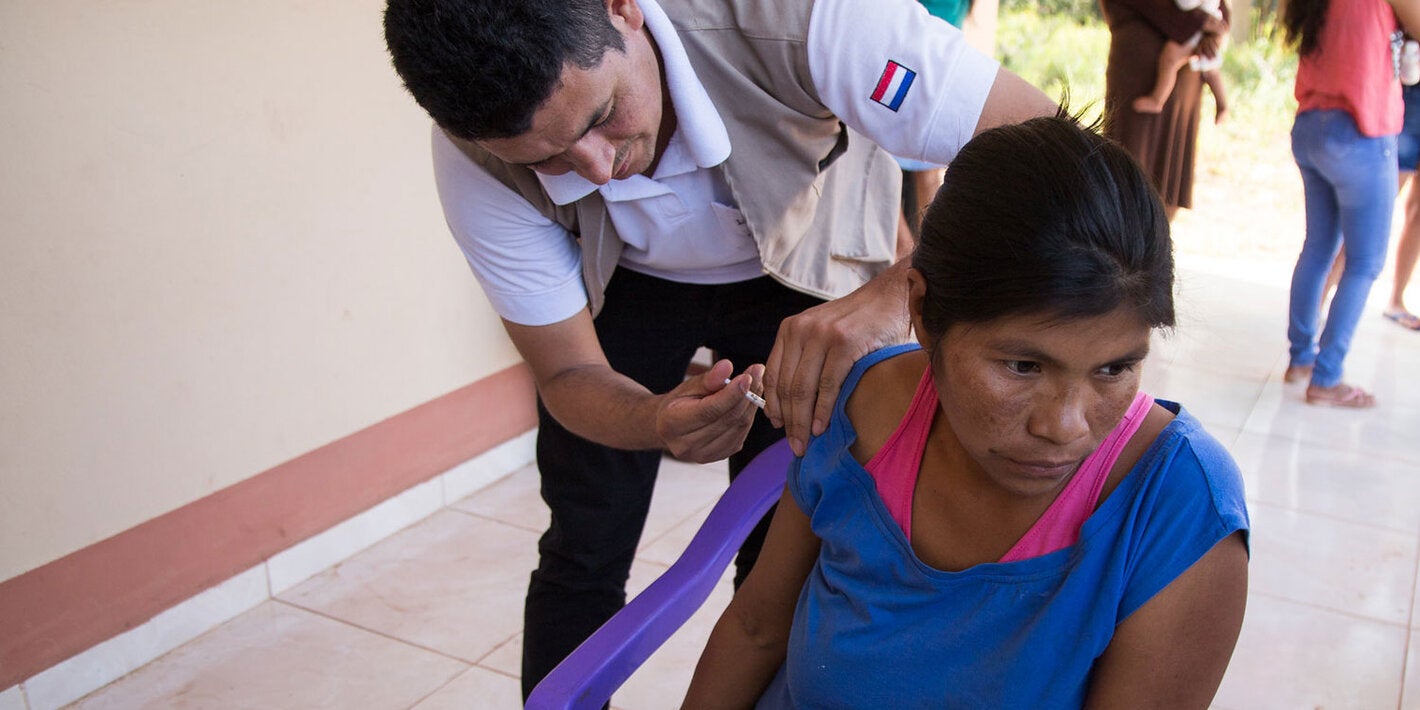 Mulher em local remoto recebe vacinação