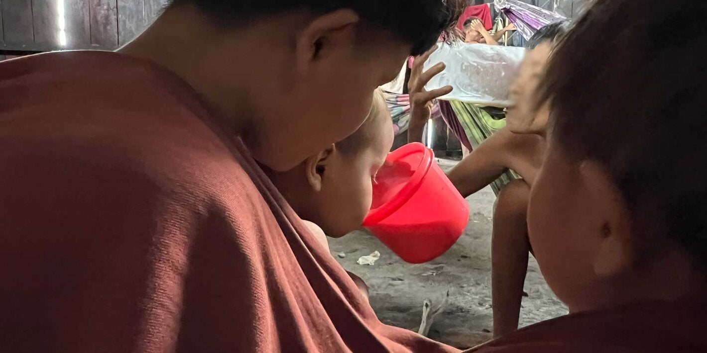 Criança Yanomami bebendo o leite terapêutico