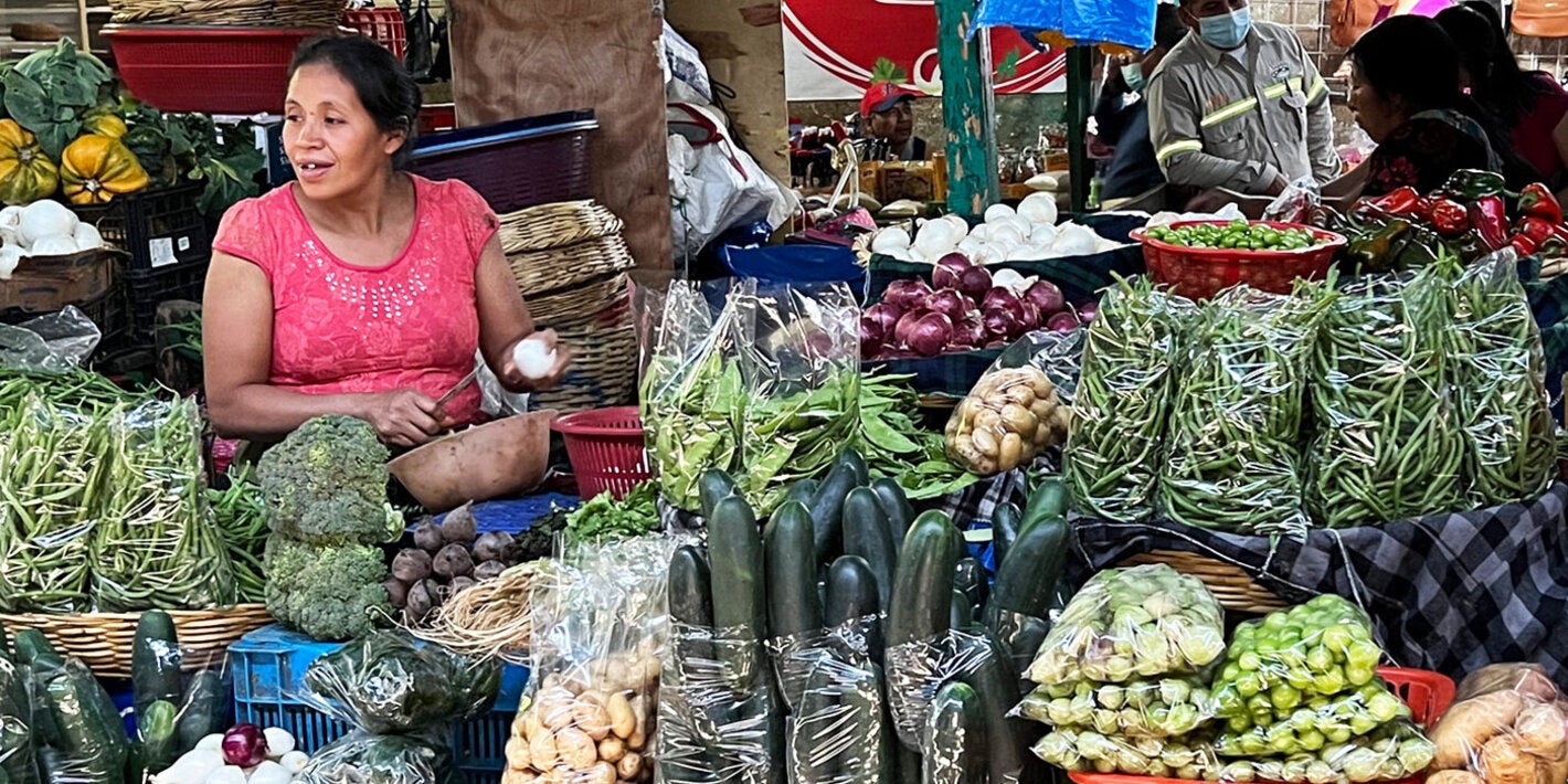 mujer vendiendo verduras en mercado tradicional en Guatemala