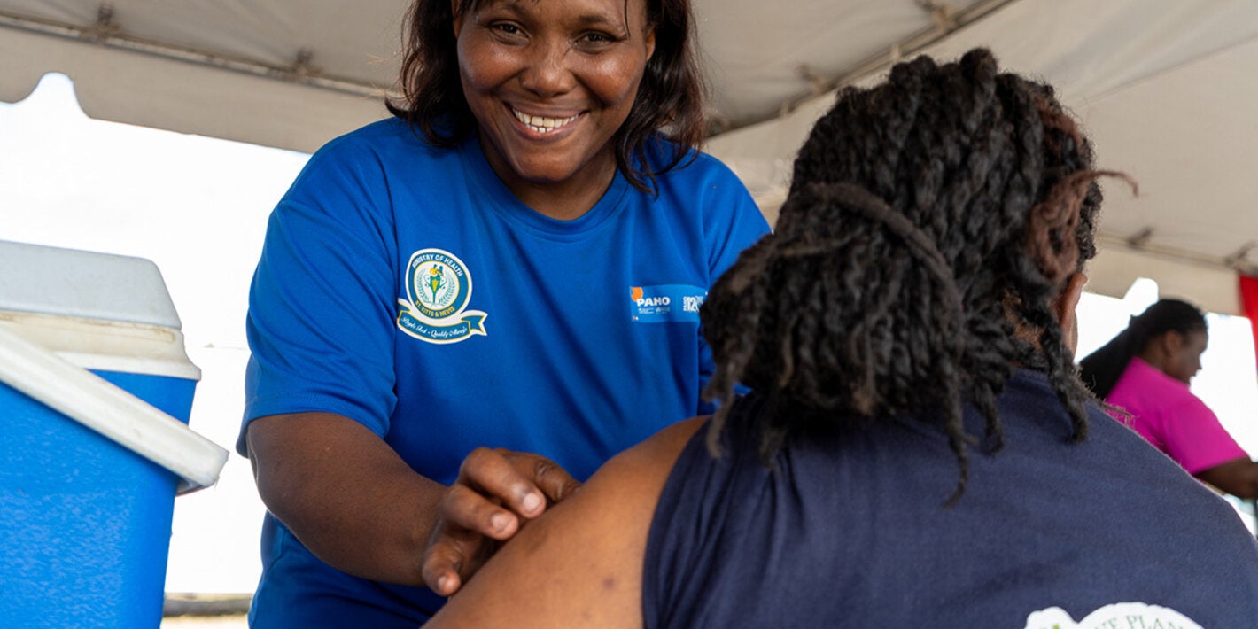 A nurse prepares to vaccinate an adult