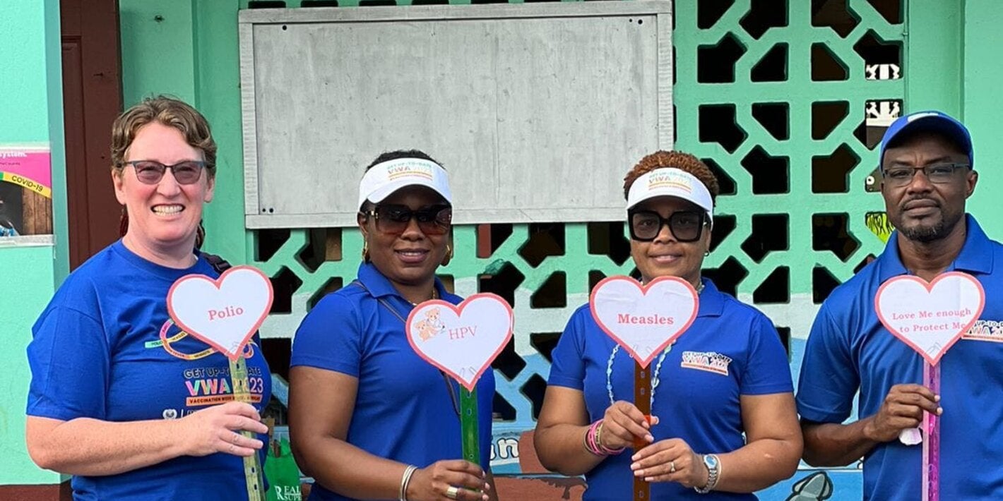 Group standing with vaccination placards