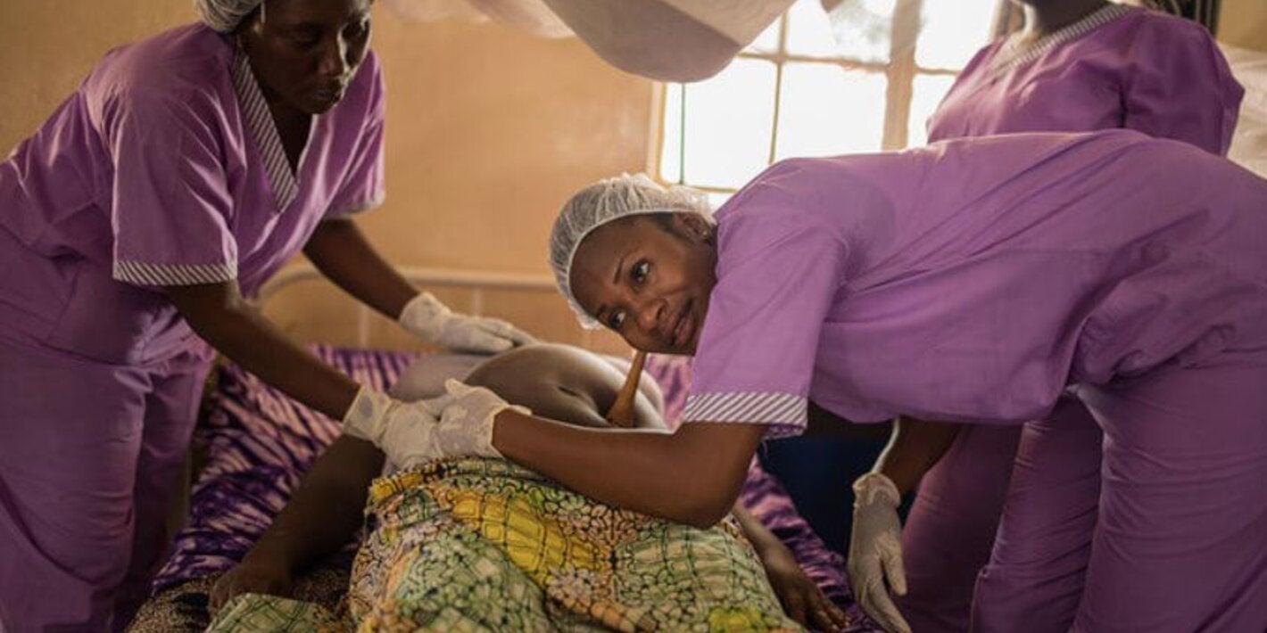 enfermeras o matronas junto a embarazada acostada