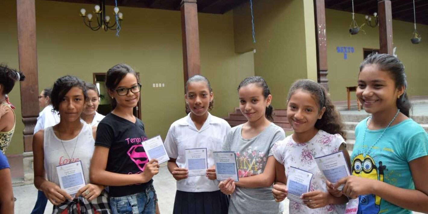 Niñas mostrando carnet de vacunación VPH