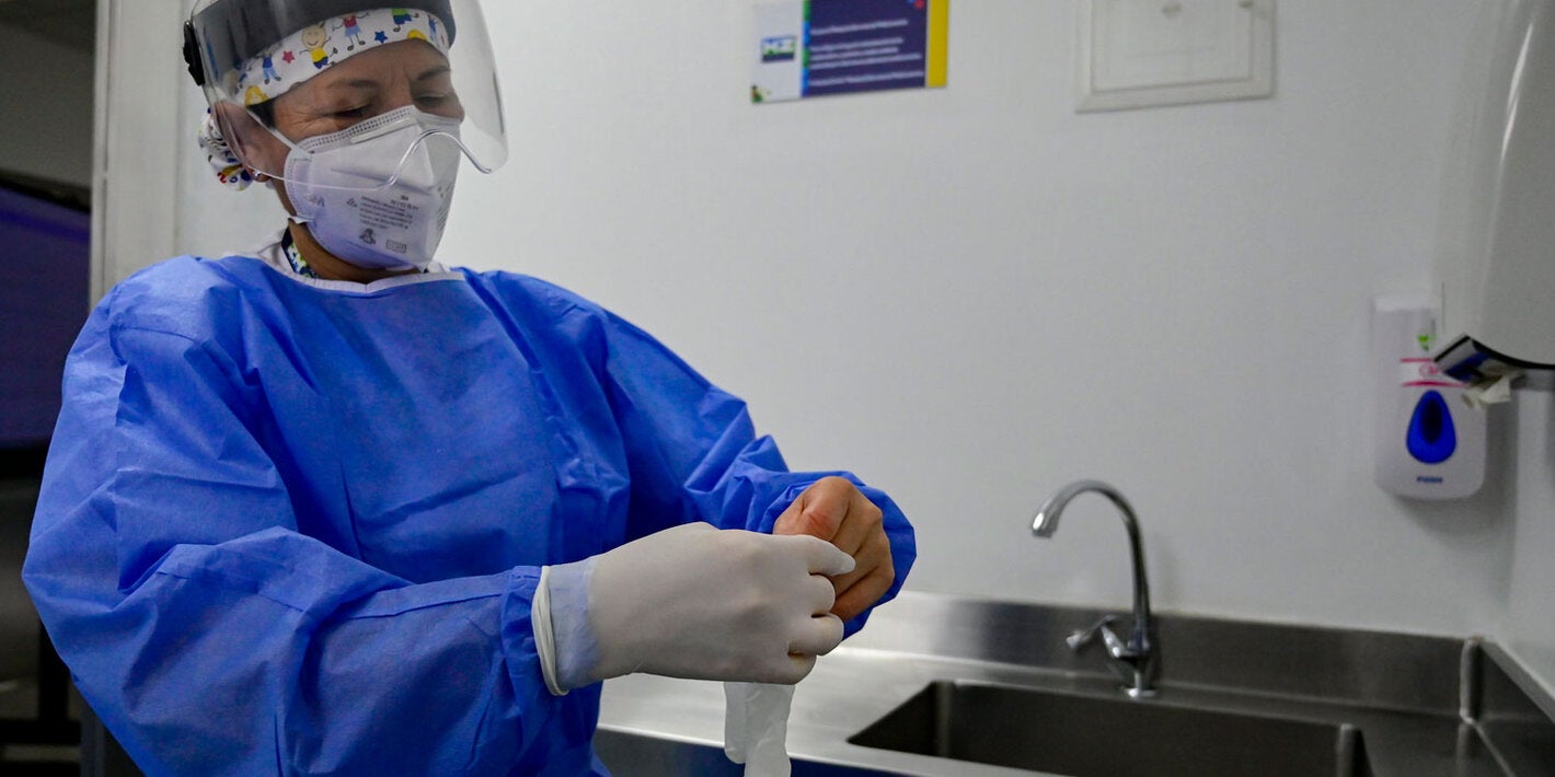 Trabajadora de salud se pone guantes