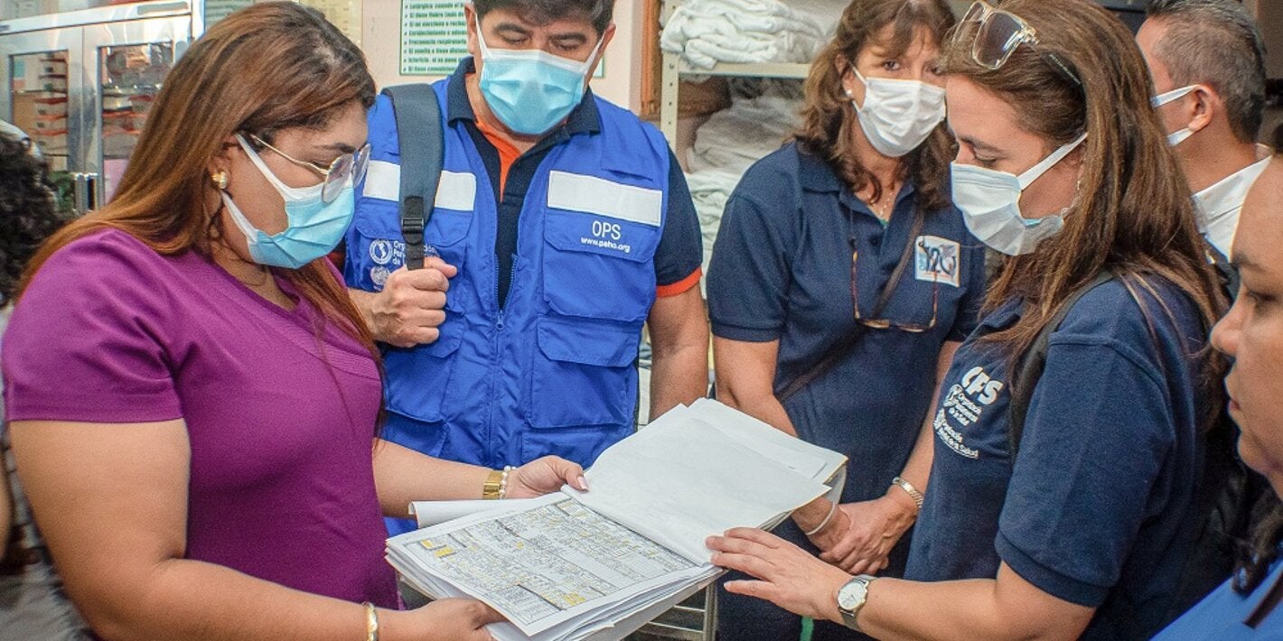 Personal de CLAP y del hospital mirando hoja SIP