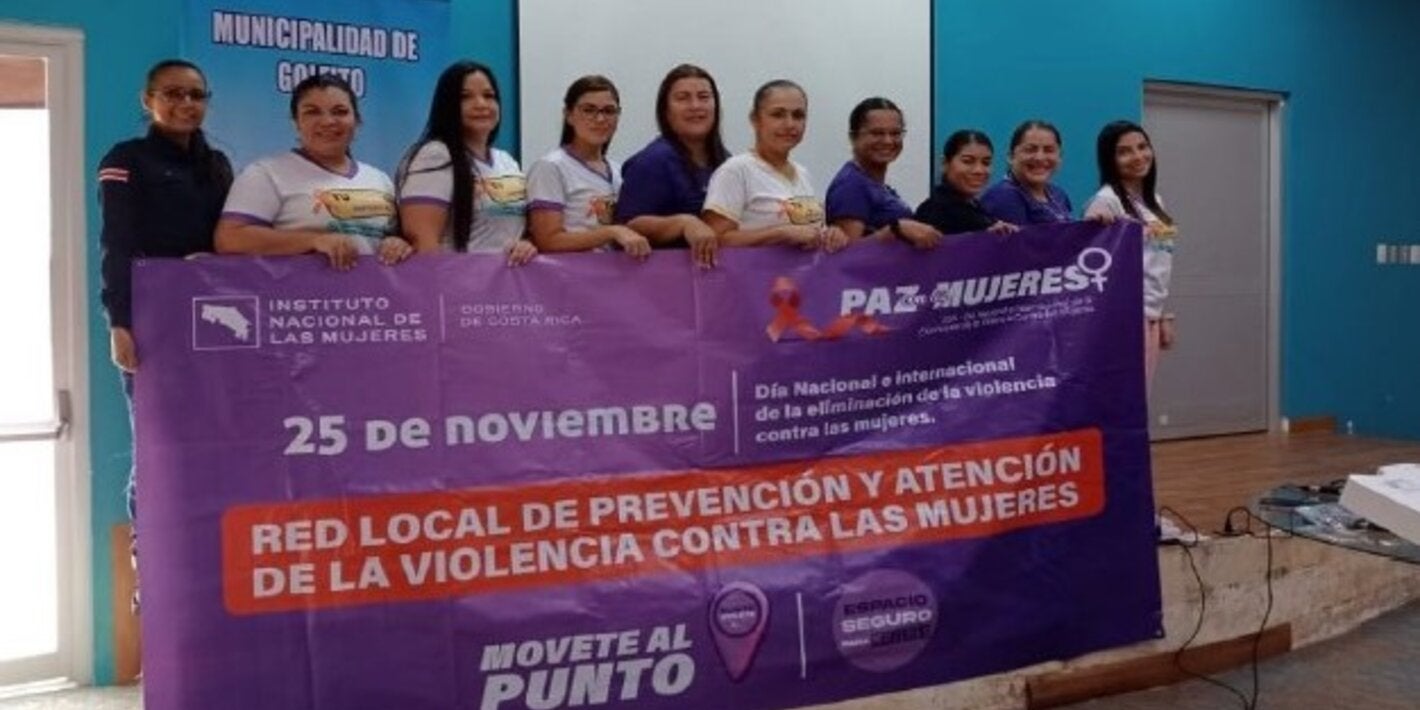 Grupo de mujeres participantes sosteniendo una pancarta
