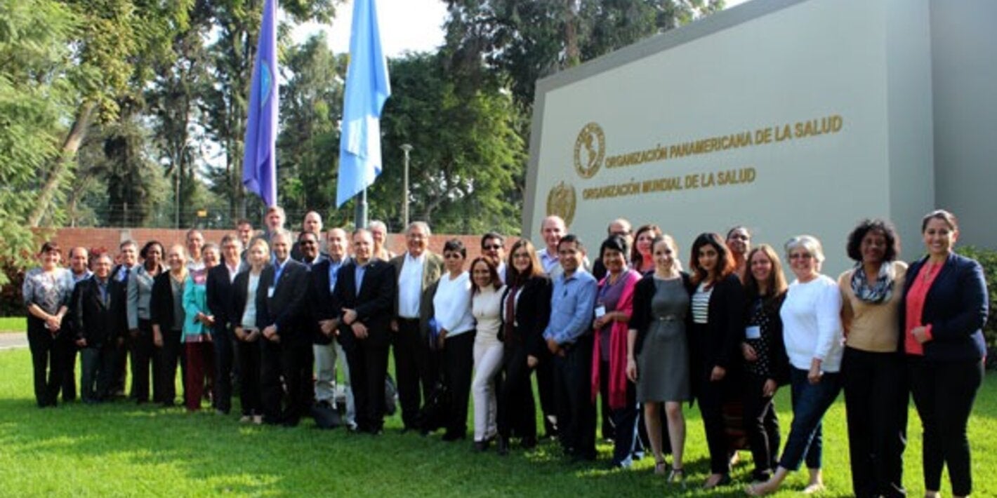 participantes de la reunion posan frente a la entrada oficina