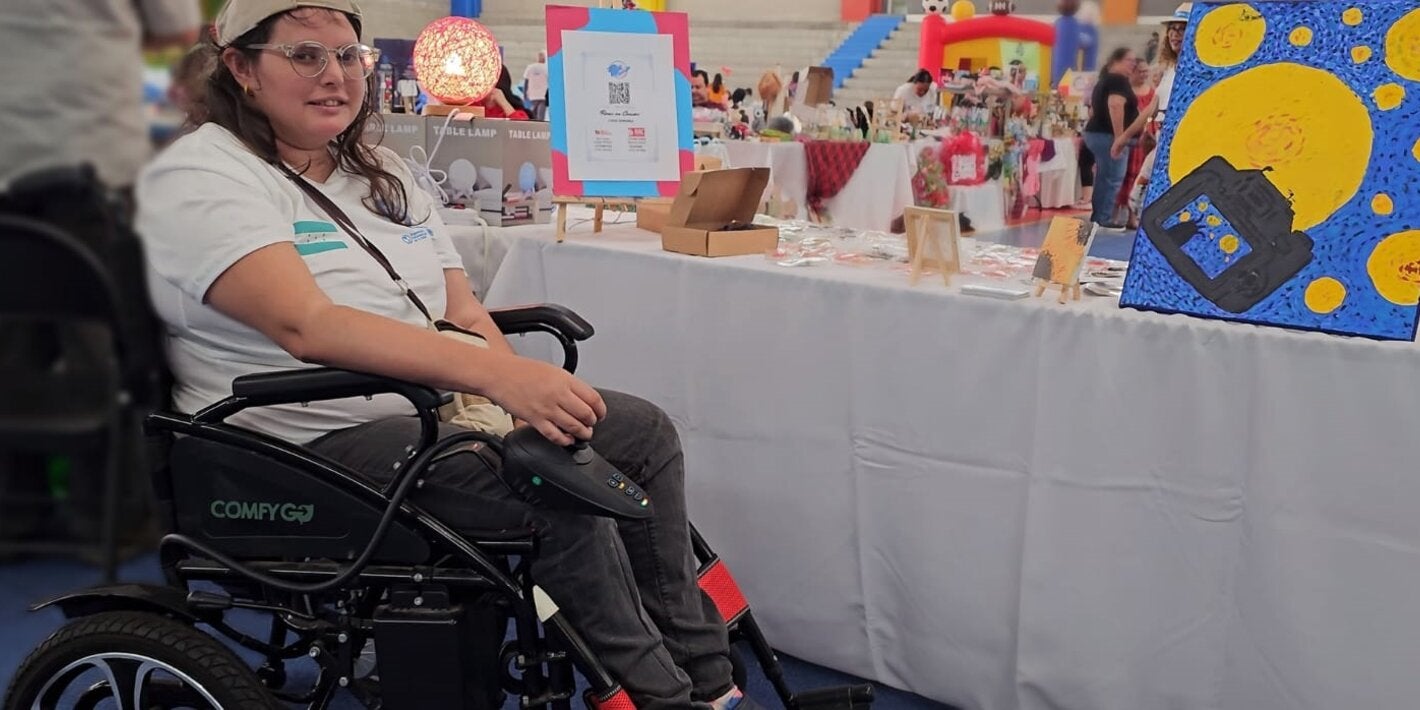 persona en silla de ruedas en feria de emprendedores