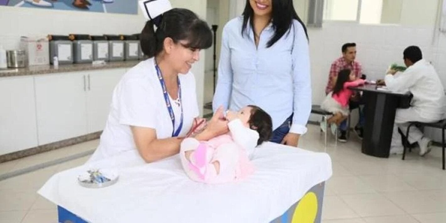 nurse interacts with infant as parent watches